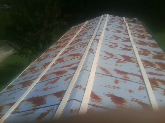 Rusted metal roof panels with new wood purlins before replacement — Storm Damage Roof Repair in Crows Landing by Roofing Brothers