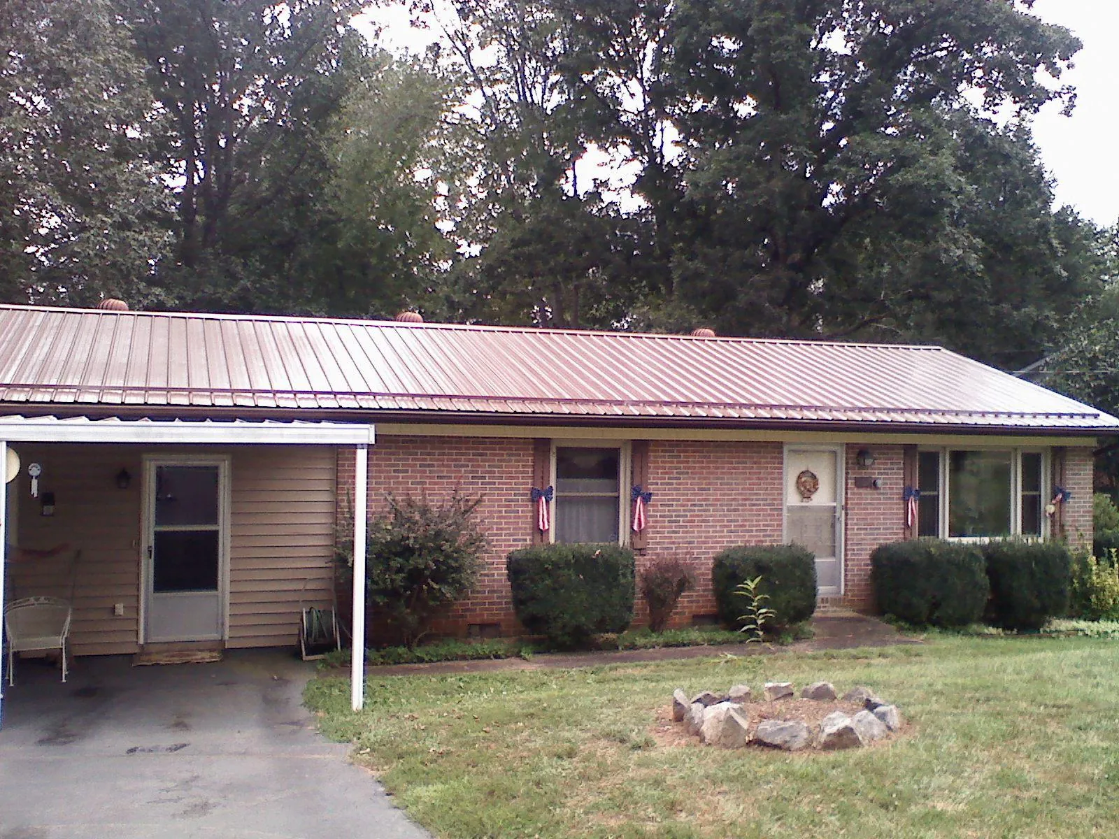 Bronze metal roof and carport on a brick ranch home — Roof Repair work by our crew in Crows Landing